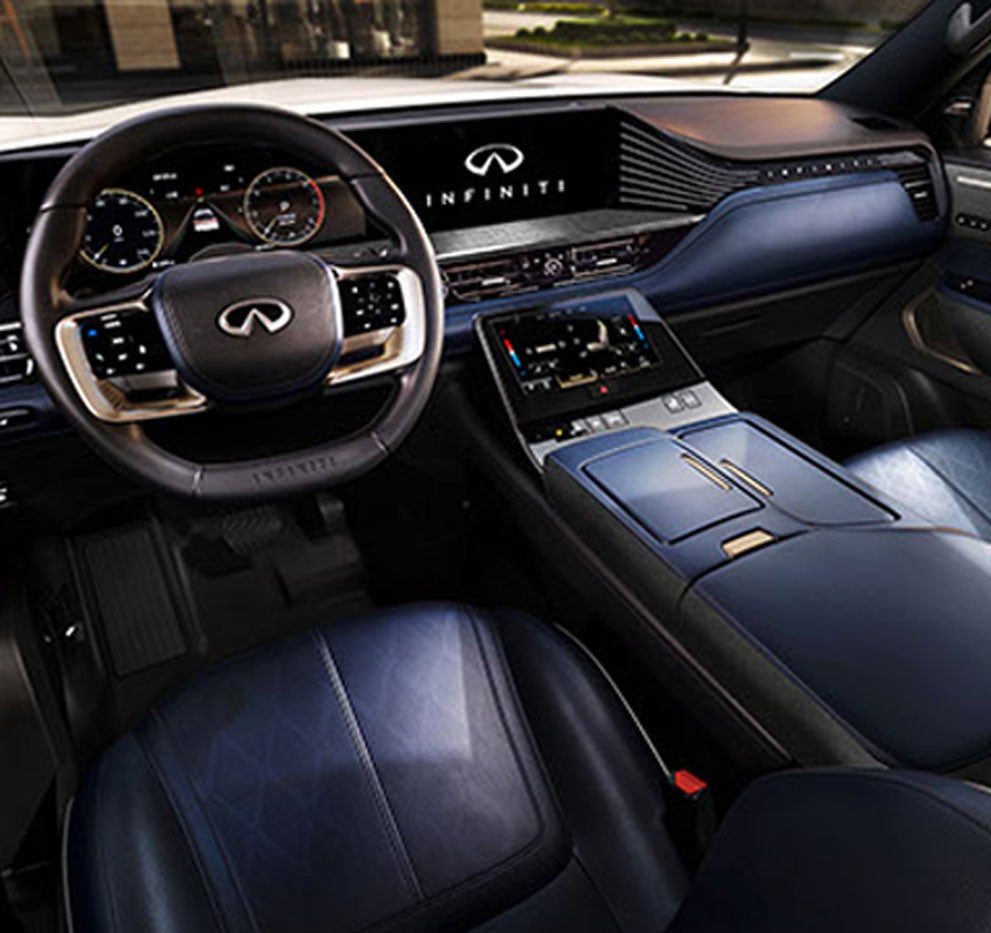 The interior of a luxury car with a dark blue dashboard, seats, and a black steering wheel.
